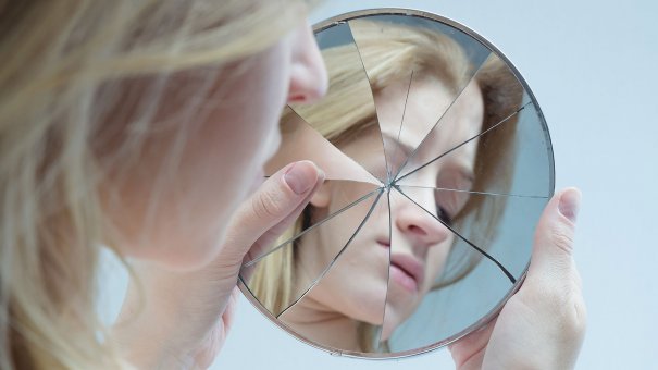 Mulher com espelho quebrado