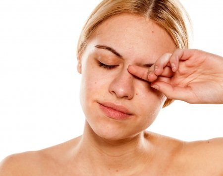 Mulher passando a mão no olho