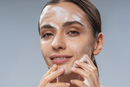 A woman using a foaming facial cleanser